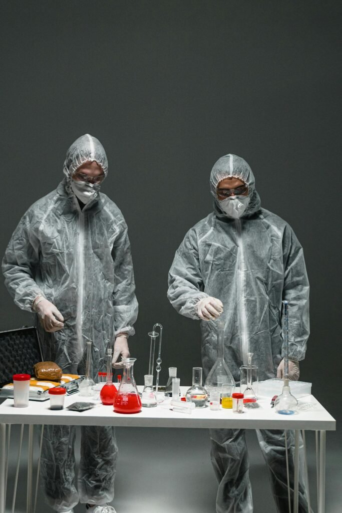Two scientists in hazmat suits conducting chemical experiments in a laboratory setting.